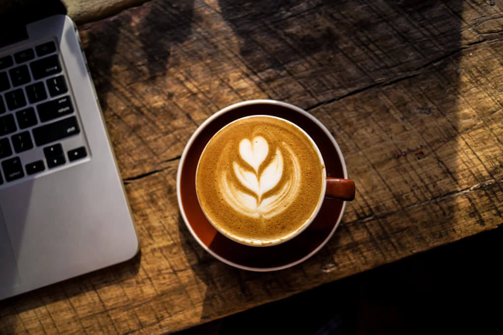 a cup of coffee with a heart shaped foam in the foam